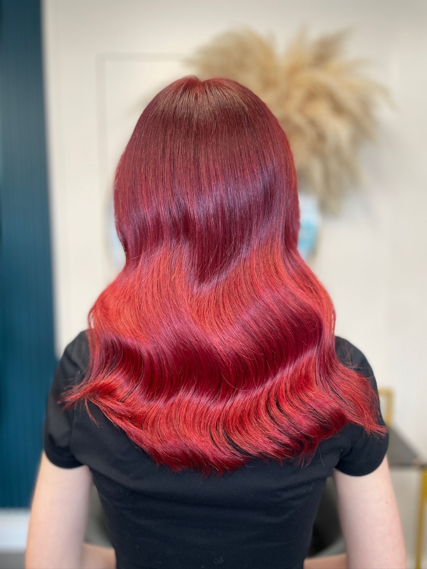 Vibrant red hair colour on long waves at ELM Hair and Beauty, Wrexham