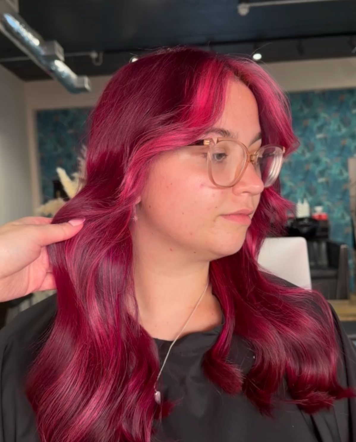 Vivid pink-red hair colour on long waves at ELM Hair and Beauty, Wrexham